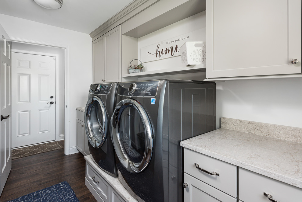 Large traditional galley utility room in Chicago with flat-panel cabinets, engineered stone countertops, white walls, dark hardwood flooring, a side by side washer and dryer, brown floors and multicoloured worktops.
