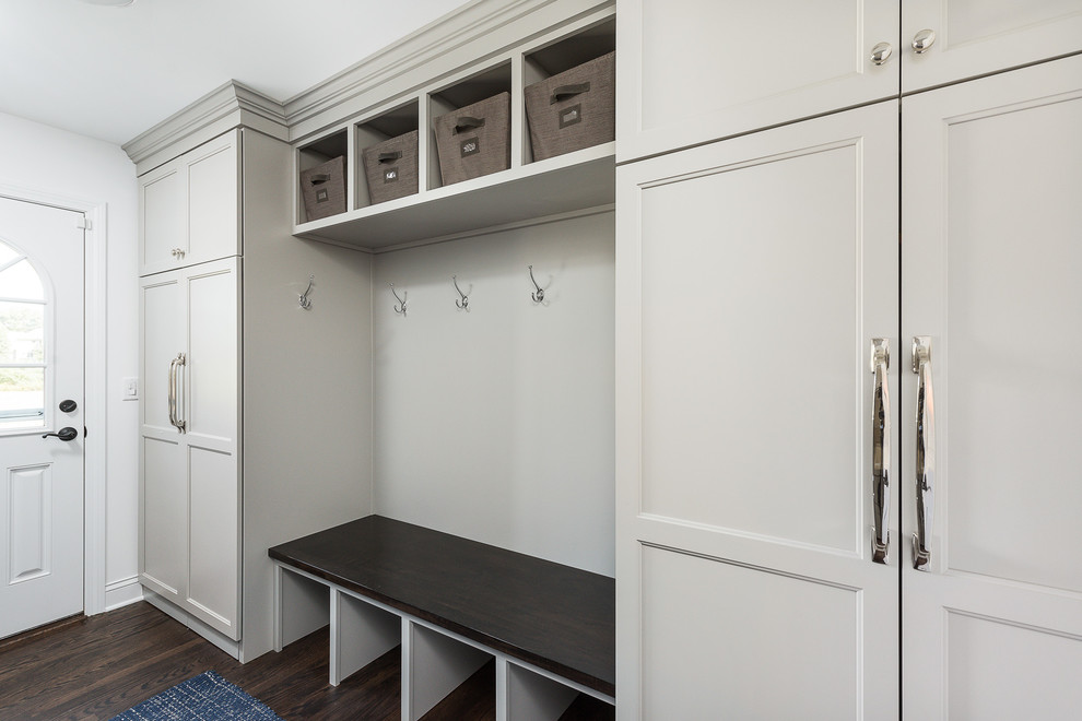 Large traditional galley utility room in Chicago with flat-panel cabinets, white walls, dark hardwood flooring, a side by side washer and dryer and brown floors.
