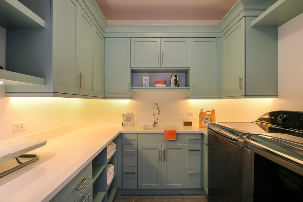 This is an example of a medium sized classic u-shaped separated utility room in Chicago with a submerged sink, flat-panel cabinets, blue cabinets, engineered stone countertops, white walls and a side by side washer and dryer.