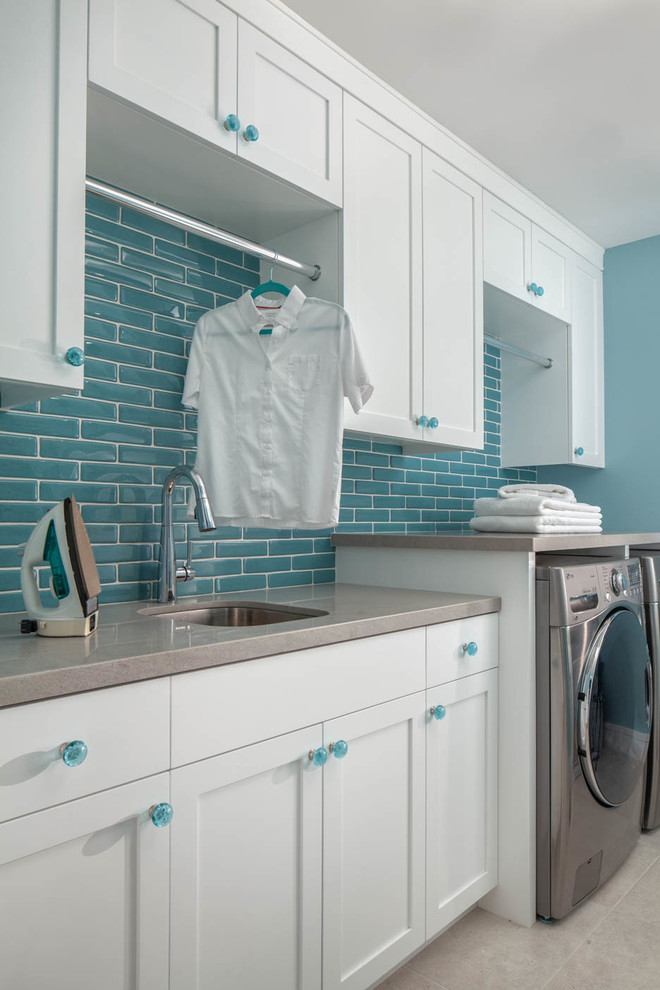 Esempio di una sala lavanderia tradizionale con lavello sottopiano, ante in stile shaker, ante bianche, pareti blu, lavatrice e asciugatrice affiancate, pavimento grigio e top grigio