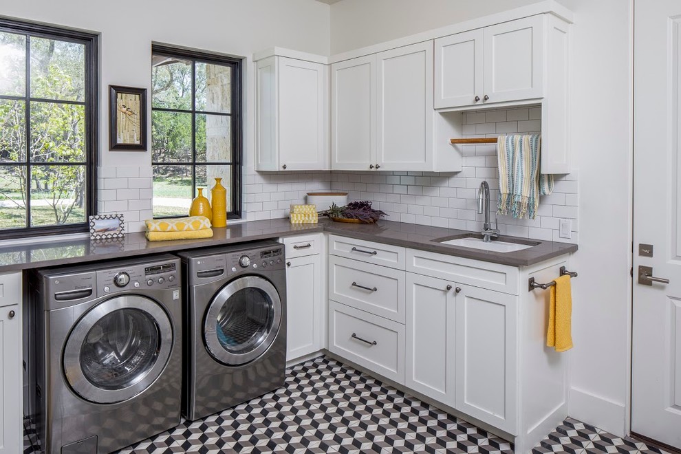 Idéer för en klassisk l-formad tvättstuga enbart för tvätt, med en undermonterad diskho, skåp i shakerstil, vita skåp, vita väggar och en tvättmaskin och torktumlare bredvid varandra