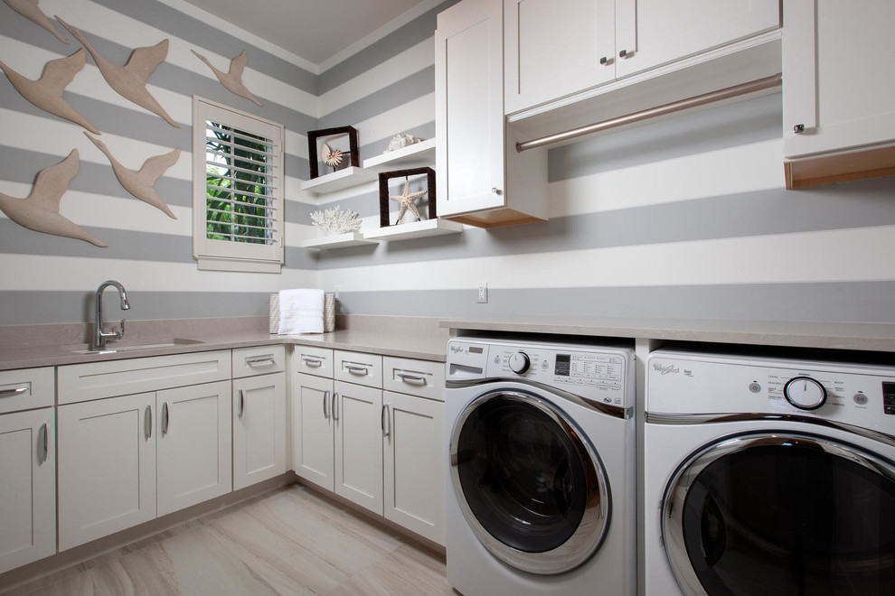マイアミにある中くらいなトランジショナルスタイルのおしゃれな洗濯室 (L型、アンダーカウンターシンク、シェーカースタイル扉のキャビネット、白いキャビネット、グレーの壁、左右配置の洗濯機・乾燥機) の写真