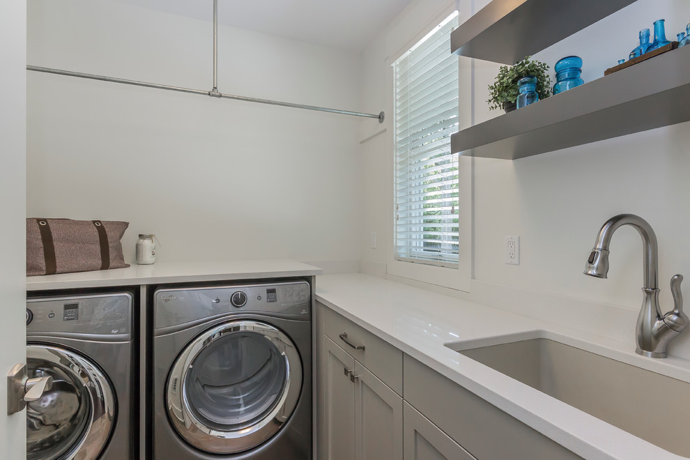 Ejemplo de lavadero tradicional renovado pequeño con fregadero bajoencimera, armarios con paneles empotrados, puertas de armario grises, encimera de cuarzo compacto y paredes grises