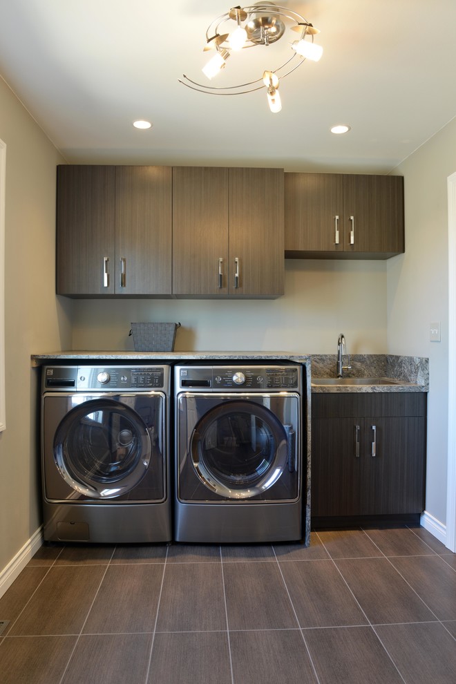 Small classic single-wall separated utility room in Other with a built-in sink, flat-panel cabinets, dark wood cabinets, engineered stone countertops, beige walls, porcelain flooring and a side by side washer and dryer.