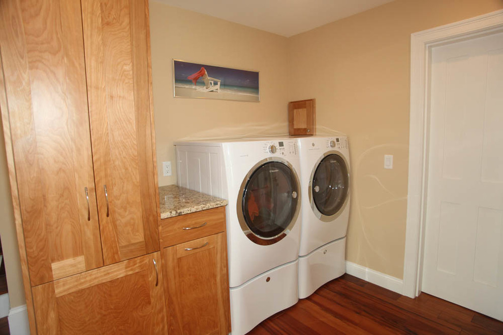 Photo of a small classic single-wall separated utility room in Boston with shaker cabinets, light wood cabinets, granite worktops, yellow walls, dark hardwood flooring, a side by side washer and dryer and beige worktops.
