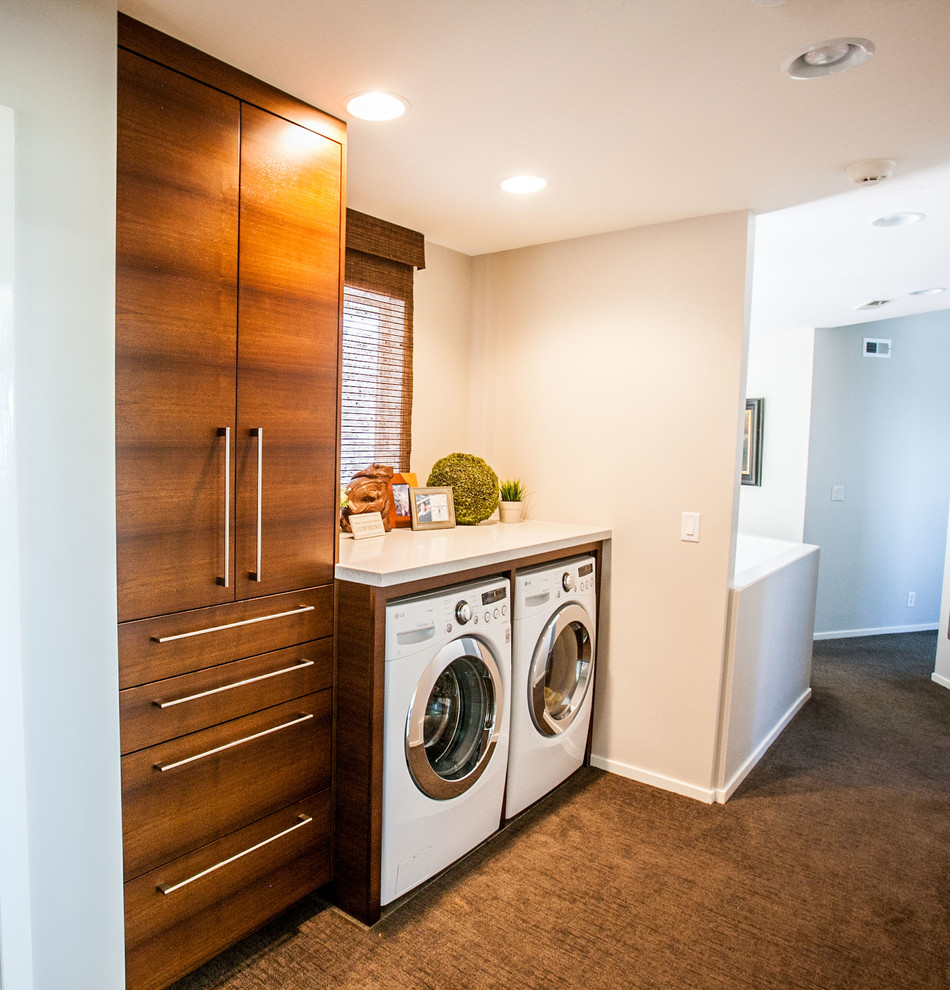 Inspiration for a large modern single-wall carpeted laundry room remodel in Salt Lake City with an utility sink, flat-panel cabinets, granite countertops, white walls, a side-by-side washer/dryer and dark wood cabinets