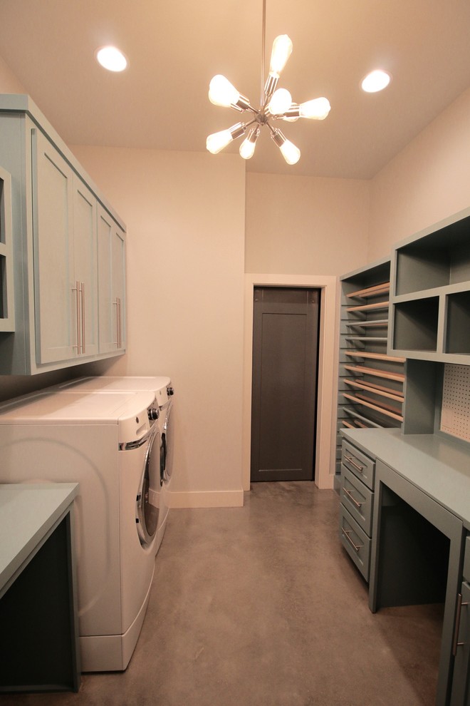 Large arts and crafts galley concrete floor and gray floor utility room photo in Other with shaker cabinets, blue cabinets, wood countertops, beige walls, a side-by-side washer/dryer and blue countertops
