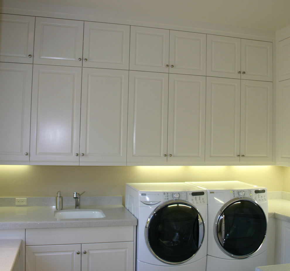 Medium sized traditional u-shaped separated utility room in Sacramento with a submerged sink, raised-panel cabinets, white cabinets, granite worktops, beige walls and a side by side washer and dryer.