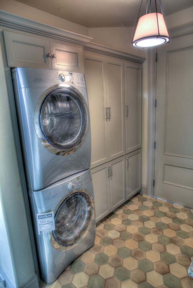 Medium sized bohemian galley utility room in Portland with a submerged sink, recessed-panel cabinets, grey cabinets, granite worktops, white walls, porcelain flooring and a stacked washer and dryer.