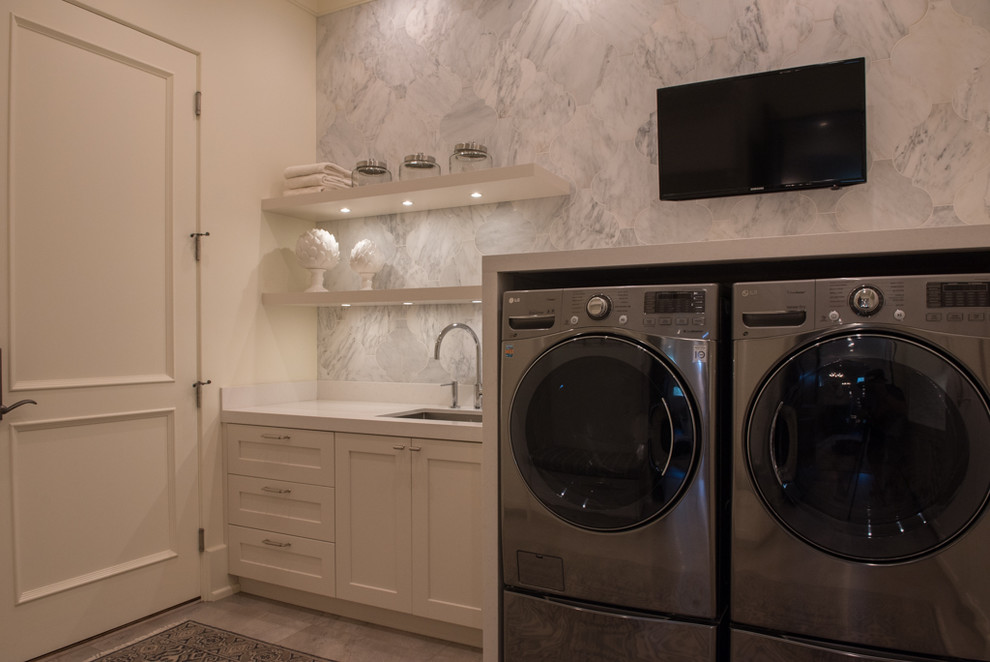 Réalisation d'une buanderie méditerranéenne avec un placard à porte shaker, des portes de placard blanches, un plan de travail en quartz modifié, un sol en carrelage de céramique et des machines côte à côte.