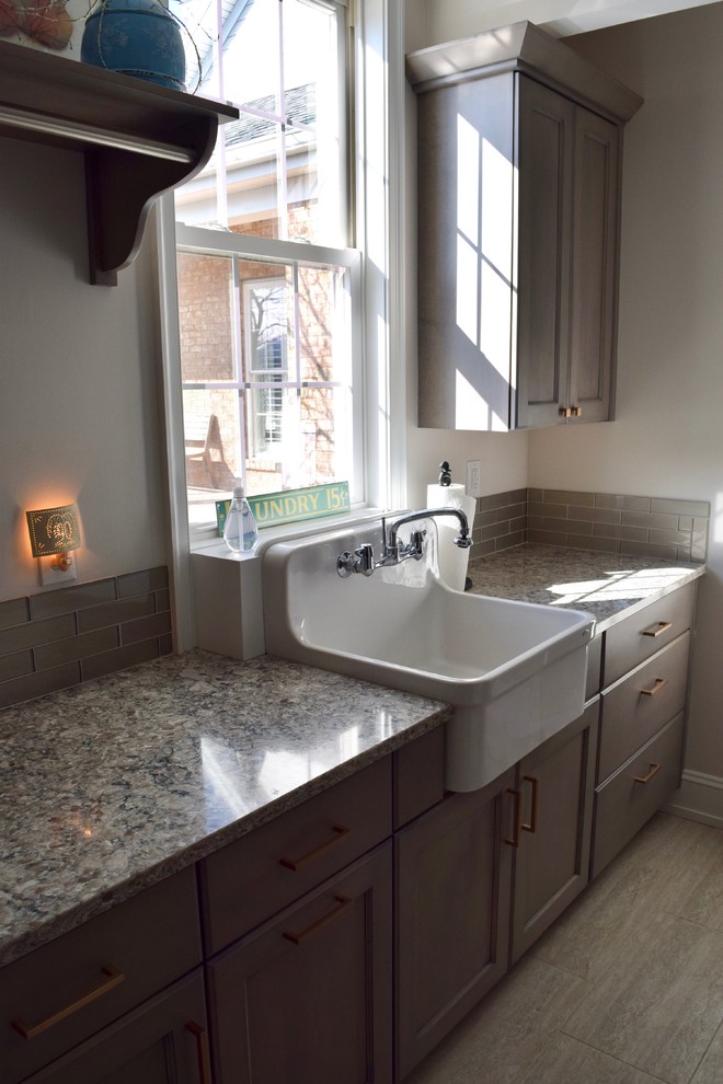 Idéer för en liten klassisk grå linjär tvättstuga enbart för tvätt, med en rustik diskho, skåp i shakerstil, skåp i mellenmörkt trä, granitbänkskiva, vita väggar, klinkergolv i porslin och brunt golv