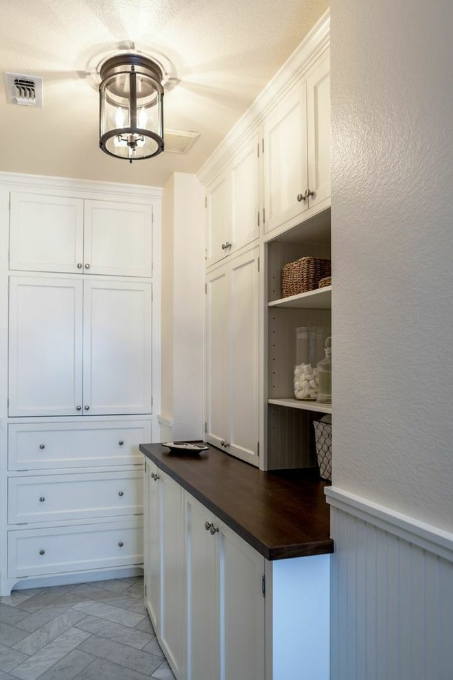 Imagen de lavadero multiusos tradicional con armarios estilo shaker, puertas de armario blancas, encimera de madera y suelo de baldosas de porcelana