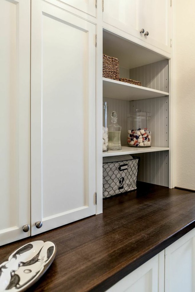 ダラスにあるトラディショナルスタイルのおしゃれな家事室 (白いキャビネット、白いキッチンパネル、シェーカースタイル扉のキャビネット、木材カウンター、磁器タイルの床) の写真