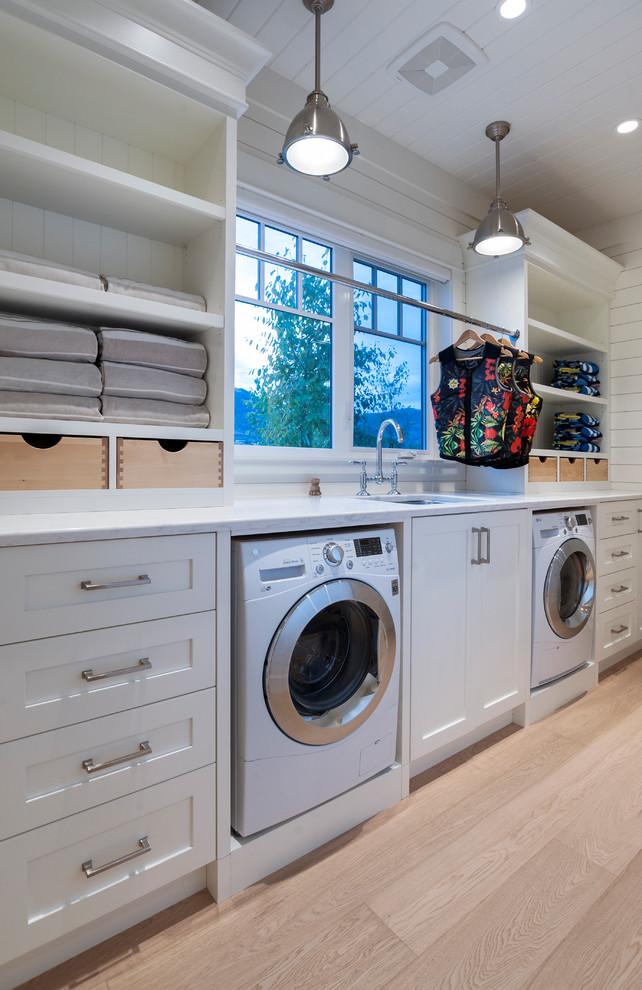 Esempio di una grande sala lavanderia costiera con lavello sottopiano, ante in stile shaker e ante bianche