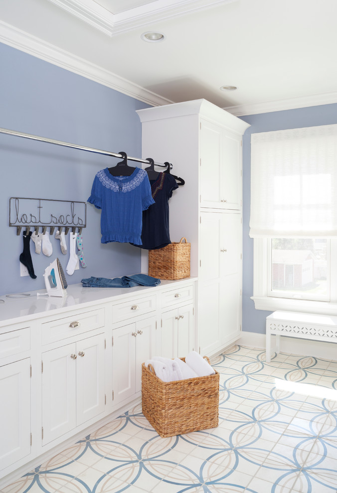 Inspiration för en stor vintage tvättstuga enbart för tvätt, med luckor med infälld panel, vita skåp, bänkskiva i kvarts, blå väggar, klinkergolv i keramik och en tvättmaskin och torktumlare bredvid varandra