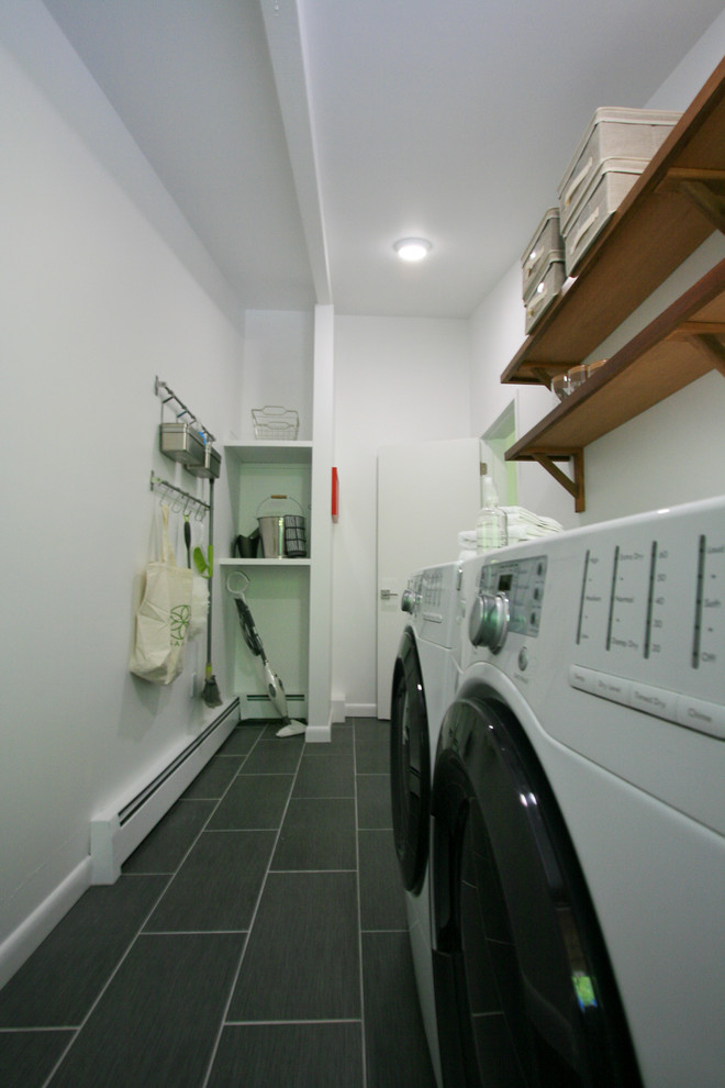 This is an example of a contemporary utility room in Boston with porcelain flooring and a side by side washer and dryer.