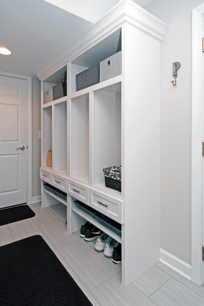 Immagine di una piccola lavanderia multiuso classica con ante bianche, pareti grigie, pavimento in gres porcellanato e lavatrice e asciugatrice affiancate
