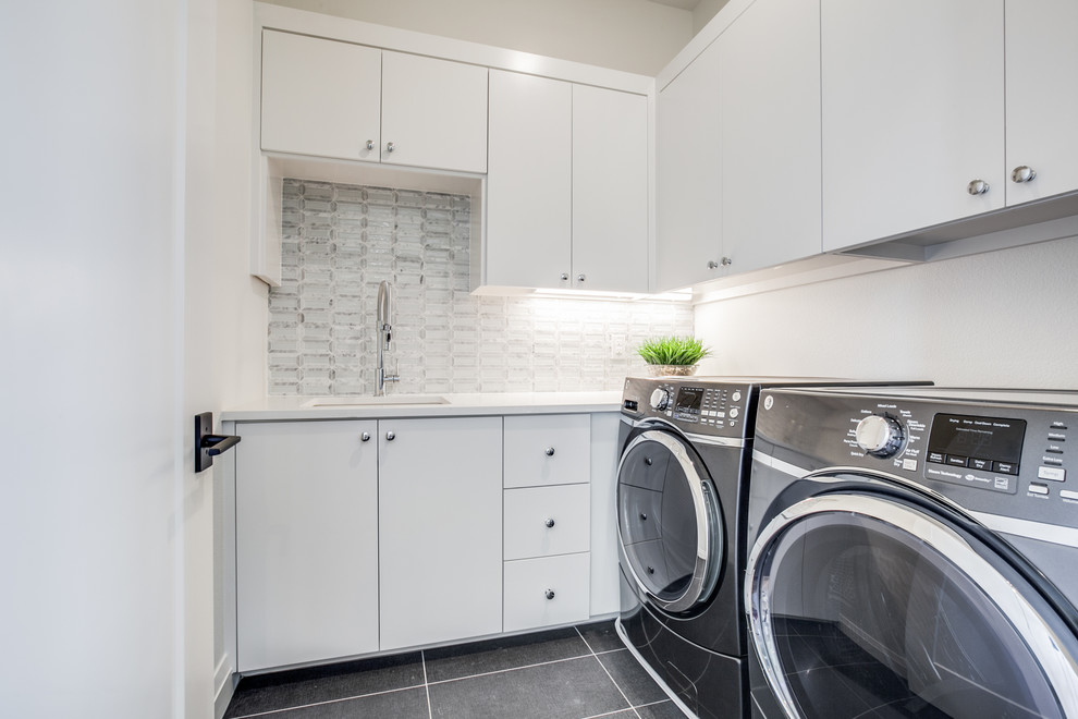 Inspiration for a mid-sized mediterranean l-shaped porcelain tile and gray floor dedicated laundry room remodel in Dallas with a drop-in sink, flat-panel cabinets, white cabinets, quartzite countertops, white walls, a side-by-side washer/dryer and white countertops