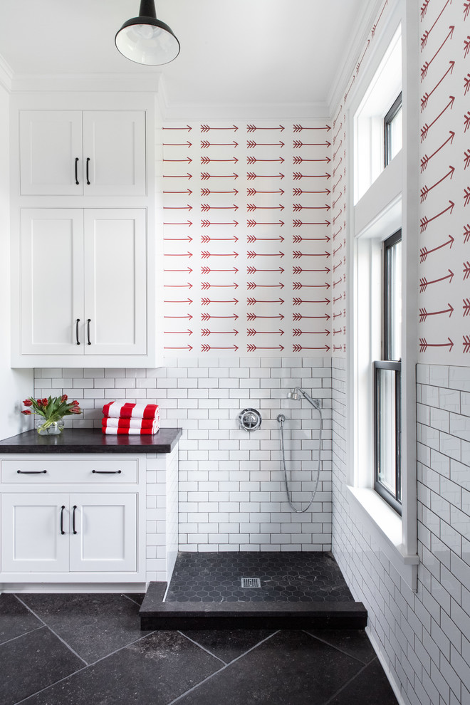 Exempel på ett stort lantligt grå u-format grått grovkök, med en undermonterad diskho, luckor med infälld panel, vita skåp, bänkskiva i betong, röda väggar, kalkstensgolv, en tvättmaskin och torktumlare bredvid varandra och svart golv