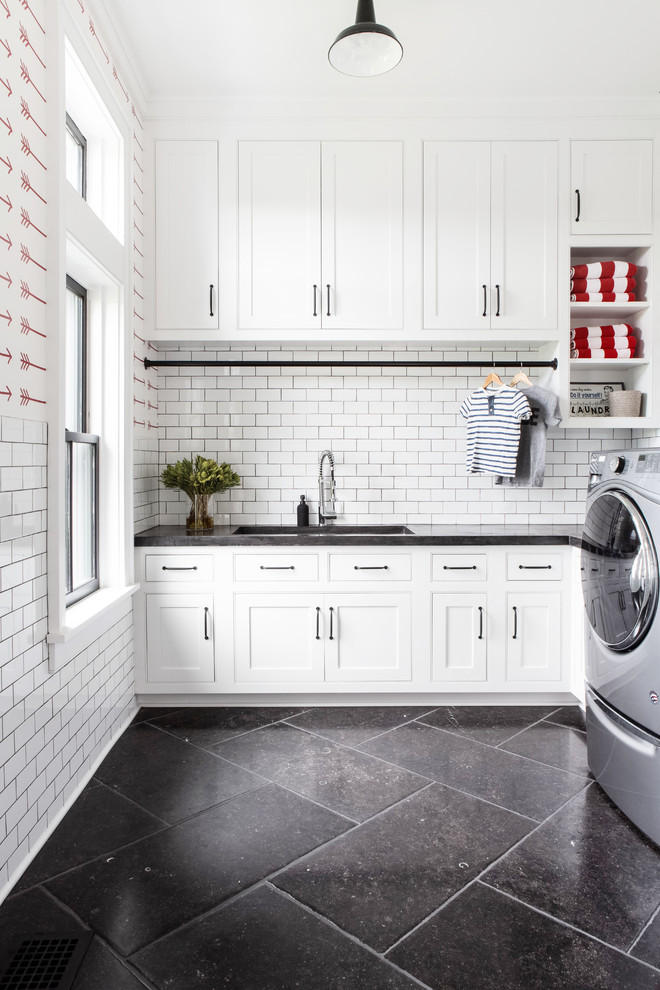 Design ideas for a large farmhouse u-shaped utility room in New York with a submerged sink, recessed-panel cabinets, white cabinets, concrete worktops, red walls, limestone flooring, a side by side washer and dryer, black floors and grey worktops.