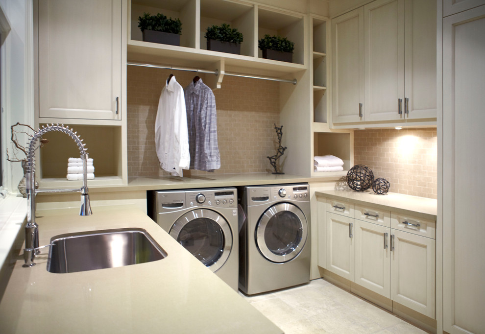 Immagine di una grande sala lavanderia tradizionale con ante in stile shaker, lavello sottopiano, ante bianche, pavimento in gres porcellanato e lavatrice e asciugatrice affiancate