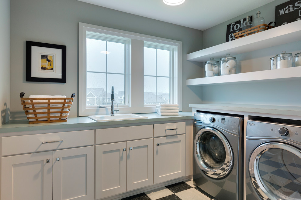 Immagine di una grande sala lavanderia classica con lavello da incasso, ante bianche, top in laminato, pareti grigie, pavimento con piastrelle in ceramica e lavatrice e asciugatrice affiancate