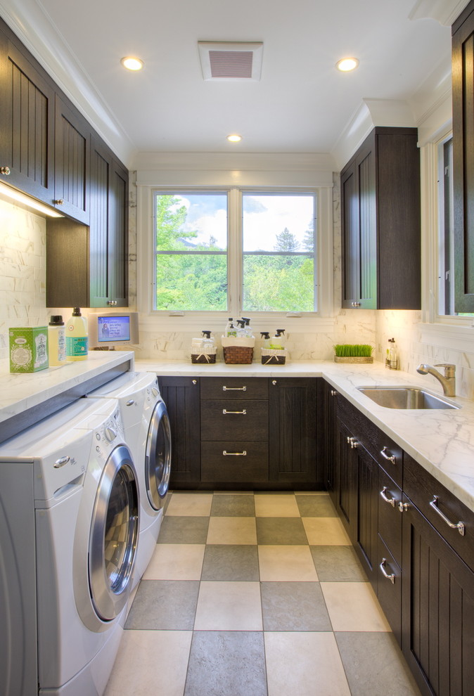Immagine di una sala lavanderia vittoriana con ante in legno bruno, lavatrice e asciugatrice affiancate e pavimento multicolore