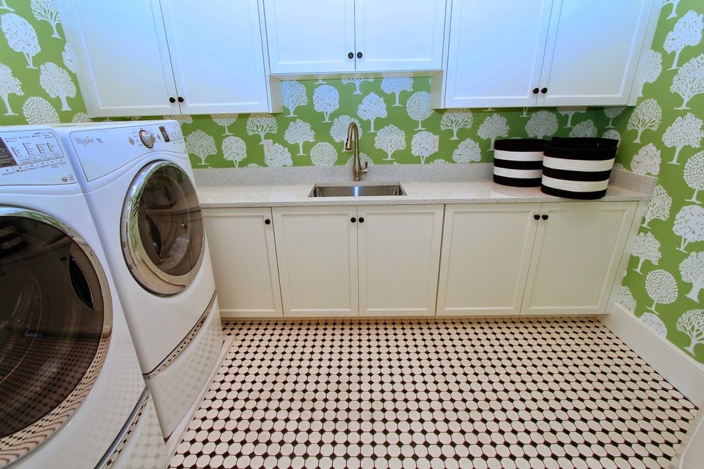 Idéer för mellanstora lantliga l-formade tvättstugor enbart för tvätt, med en undermonterad diskho, luckor med infälld panel, vita skåp, bänkskiva i kvarts, gröna väggar, klinkergolv i porslin och en tvättmaskin och torktumlare bredvid varandra