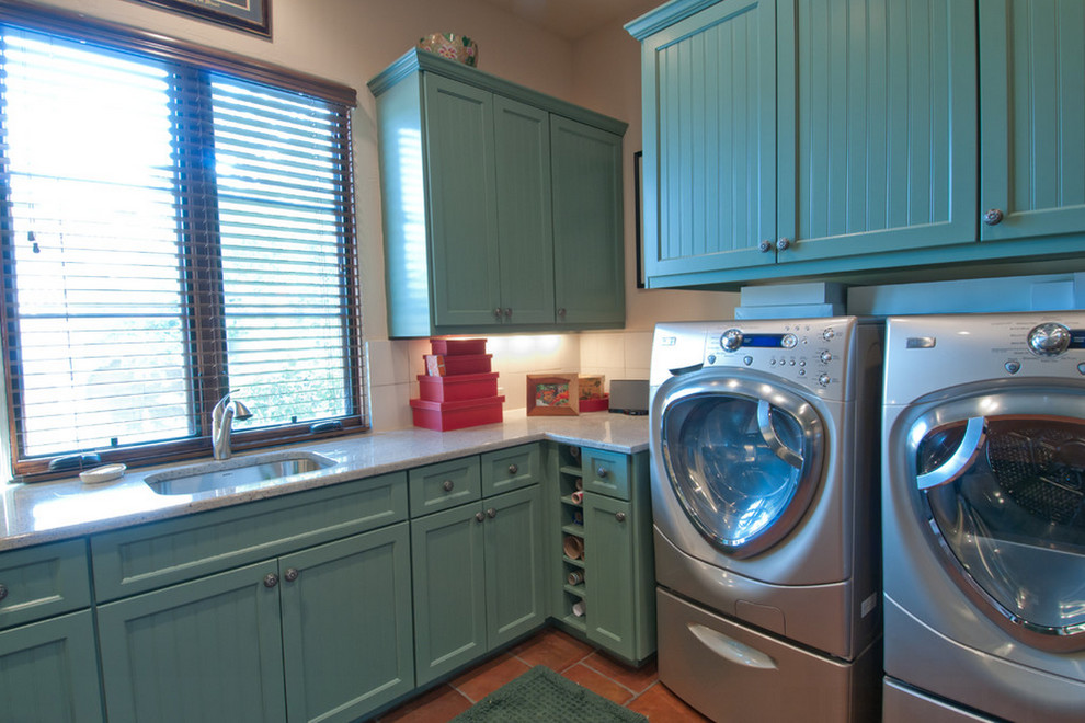 Foto di una lavanderia multiuso country di medie dimensioni con lavello sottopiano, top in granito, lavatrice e asciugatrice affiancate e ante blu