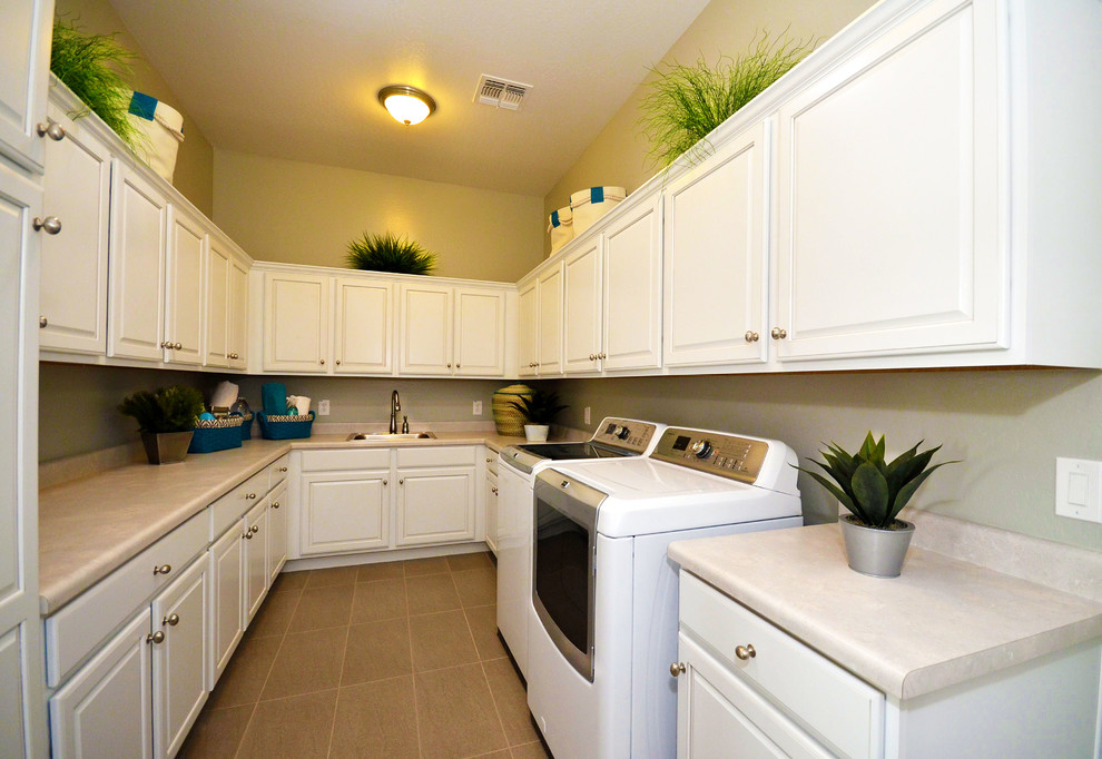 Dedicated laundry room - mid-sized transitional u-shaped ceramic tile dedicated laundry room idea in Phoenix with a drop-in sink, raised-panel cabinets, white cabinets, laminate countertops, beige walls and a side-by-side washer/dryer