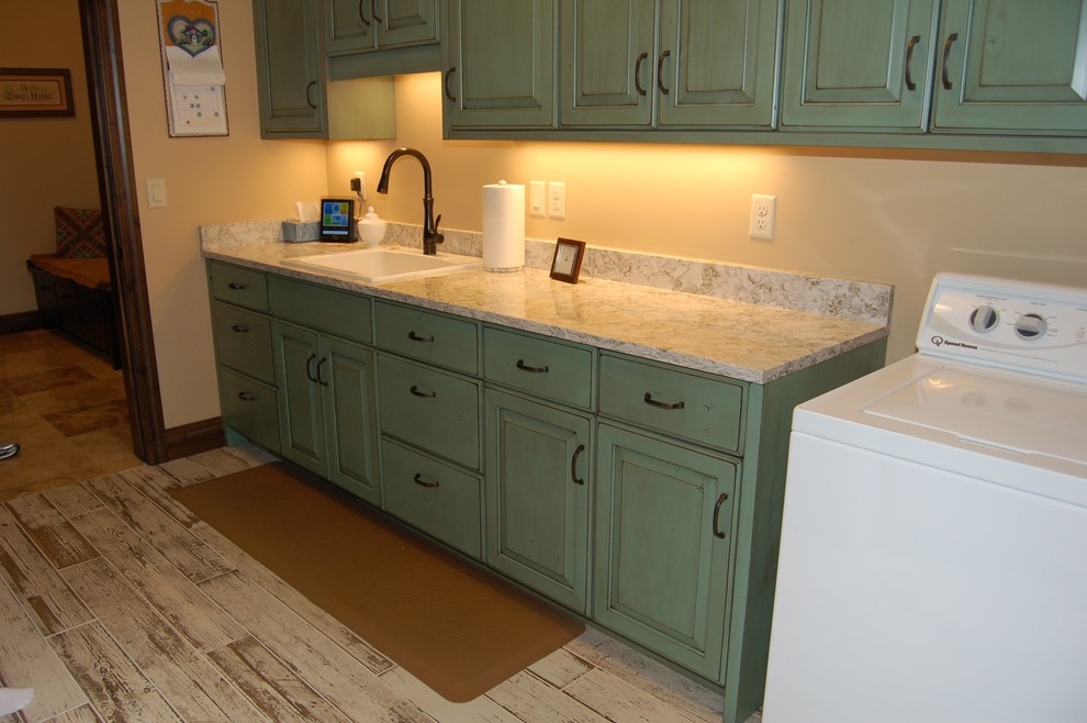Farmhouse laundry room photo in Salt Lake City with a drop-in sink, raised-panel cabinets, green cabinets, granite countertops, beige walls and a side-by-side washer/dryer
