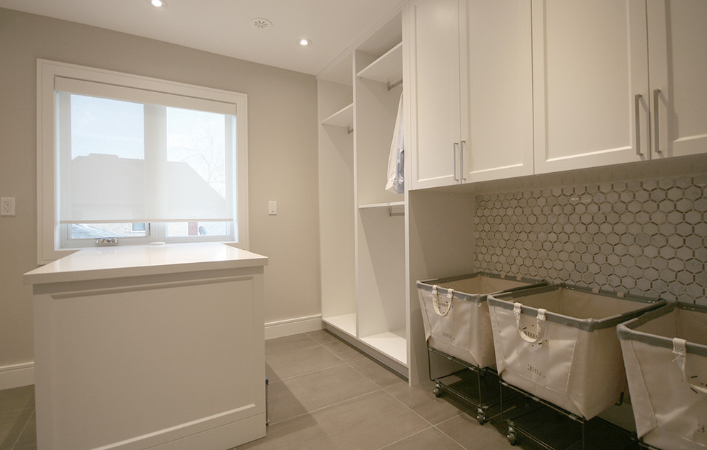 Photo of a large contemporary galley separated utility room in Toronto with a submerged sink, shaker cabinets, white cabinets, quartz worktops, beige walls, concrete flooring, a side by side washer and dryer, grey floors and white worktops.