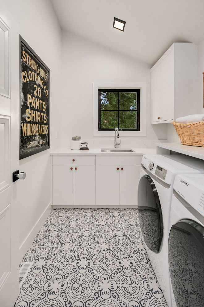 シアトルにある高級な広いカントリー風のおしゃれな洗濯室 (アンダーカウンターシンク、フラットパネル扉のキャビネット、白いキャビネット、白い壁、左右配置の洗濯機・乾燥機、白いキッチンカウンター) の写真