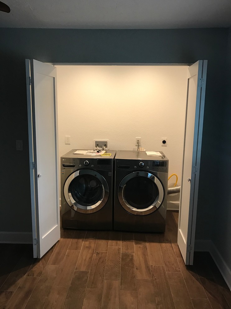 Small elegant single-wall porcelain tile and brown floor laundry closet photo in Tampa with a side-by-side washer/dryer
