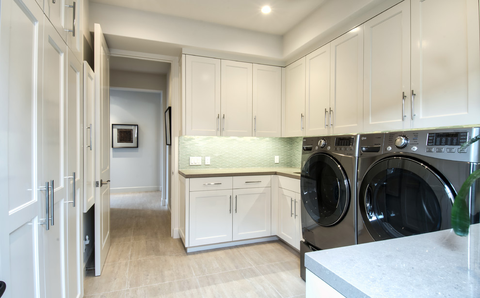 Klassische Waschküche in U-Form mit Unterbauwaschbecken, Schrankfronten im Shaker-Stil, weißen Schränken, weißer Wandfarbe und Waschmaschine und Trockner nebeneinander in Orange County