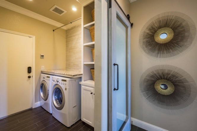 Inspiration för mellanstora moderna parallella tvättstugor enbart för tvätt, med luckor med upphöjd panel, vita skåp, granitbänkskiva, en tvättmaskin och torktumlare bredvid varandra, beige väggar, mörkt trägolv och brunt golv
