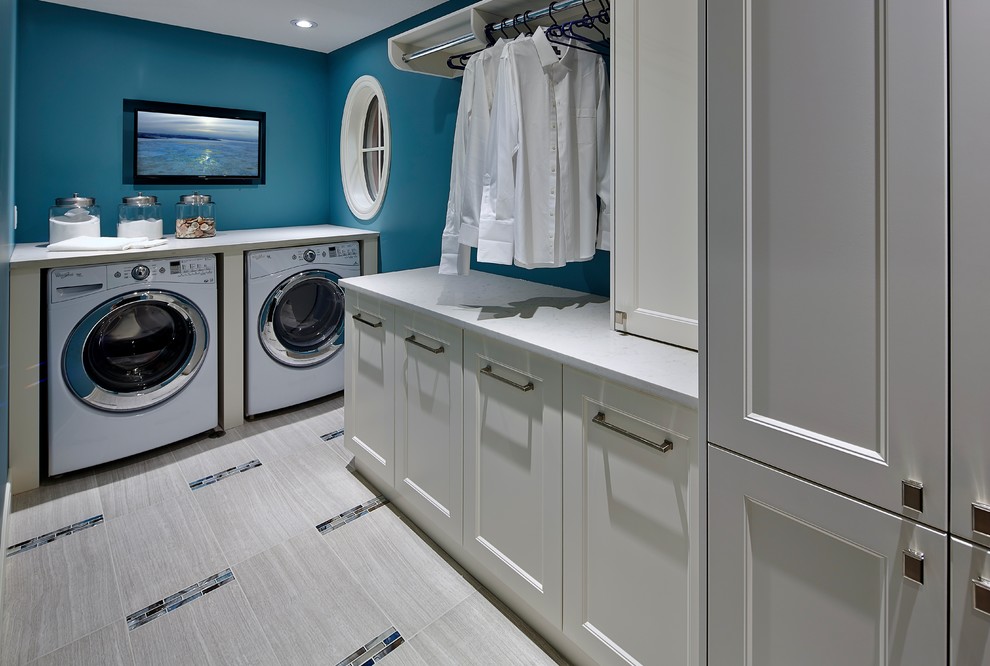 Ejemplo de lavadero multiusos y lineal grande con puertas de armario blancas, encimera de granito, paredes azules y lavadora y secadora juntas