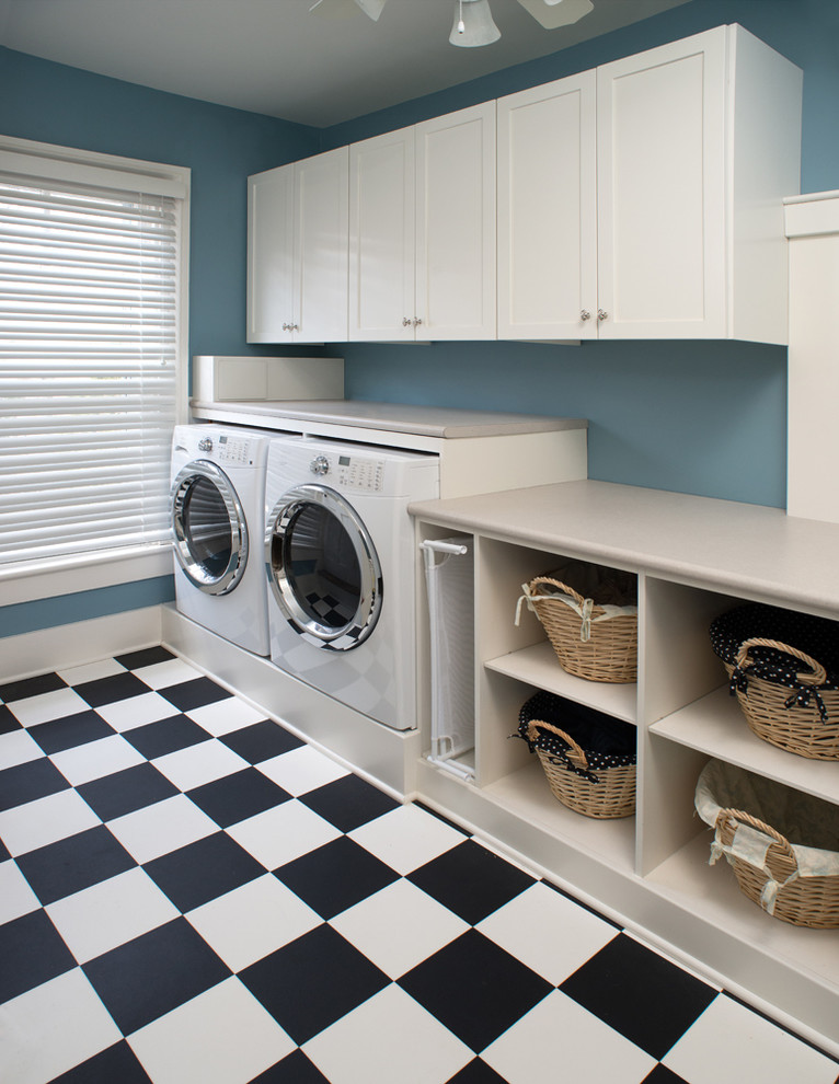 Ispirazione per una grande sala lavanderia tradizionale con ante con riquadro incassato, ante bianche, top in laminato, pareti blu, pavimento in vinile e lavatrice e asciugatrice affiancate