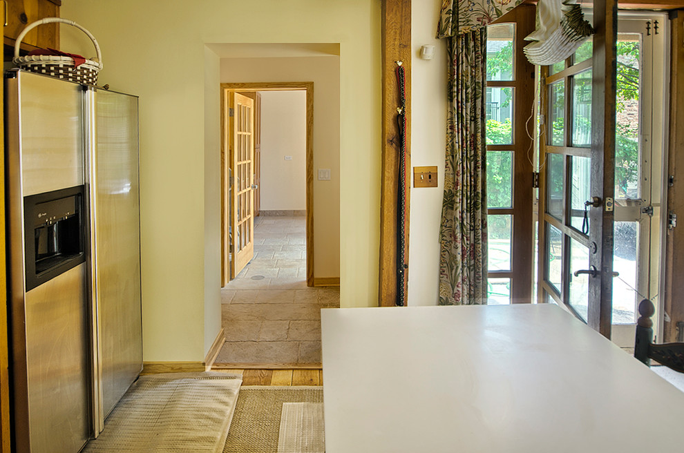Exemple d'une grande buanderie linéaire chic en bois brun multi-usage avec un évier utilitaire, un placard à porte shaker, un plan de travail en granite, un mur beige et sol en béton ciré.