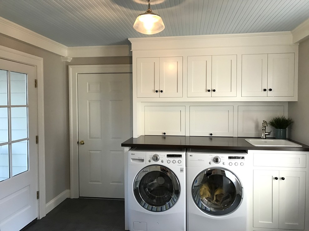 Example of a mid-sized classic u-shaped porcelain tile utility room design in New York with a drop-in sink, beaded inset cabinets, white cabinets, wood countertops, gray walls and a side-by-side washer/dryer