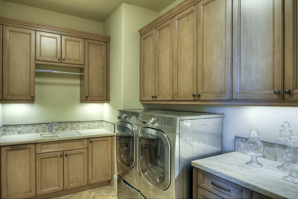 Inspiration for a large timeless u-shaped dedicated laundry room remodel in Phoenix with medium tone wood cabinets, marble countertops, beige walls and a side-by-side washer/dryer