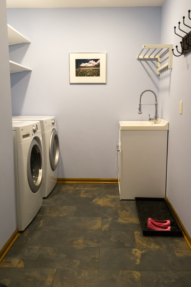 Foto på en stor vintage parallell tvättstuga enbart för tvätt, med en allbänk, öppna hyllor, vita skåp, bänkskiva i koppar, blå väggar, klinkergolv i porslin och en tvättmaskin och torktumlare bredvid varandra
