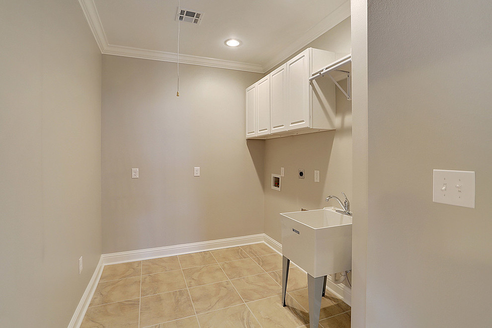 Example of a classic dedicated laundry room design in New Orleans with an utility sink and a side-by-side washer/dryer