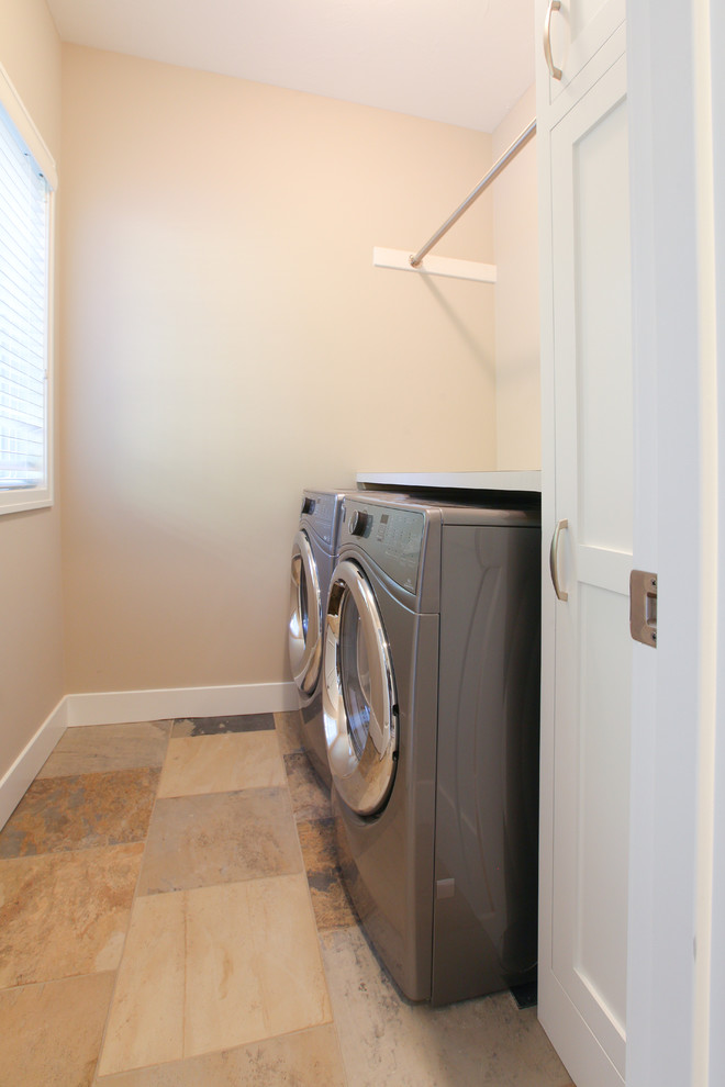 Esempio di una piccola sala lavanderia stile marinaro con ante in stile shaker, ante bianche, top in laminato, pareti beige, pavimento in ardesia e lavatrice e asciugatrice affiancate