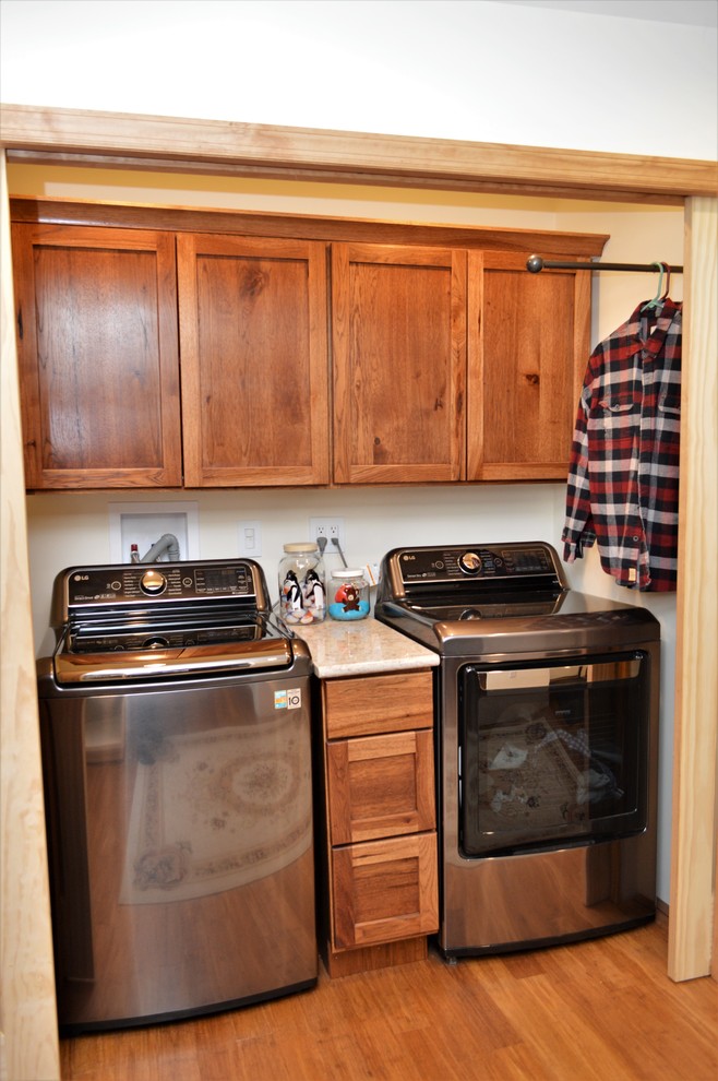 Immagine di un piccolo ripostiglio-lavanderia american style con ante in stile shaker, ante in legno bruno, top in quarzite, pareti bianche, lavatrice e asciugatrice affiancate e top beige