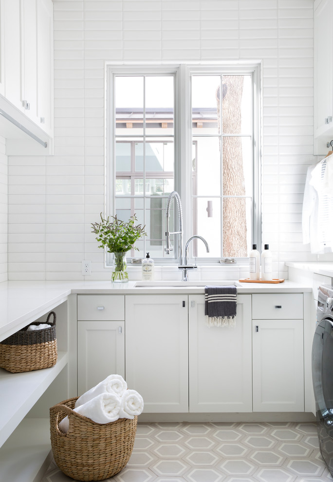 Idee per una sala lavanderia mediterranea con lavello sottopiano, ante in stile shaker, ante bianche, pareti bianche, pavimento multicolore e top bianco