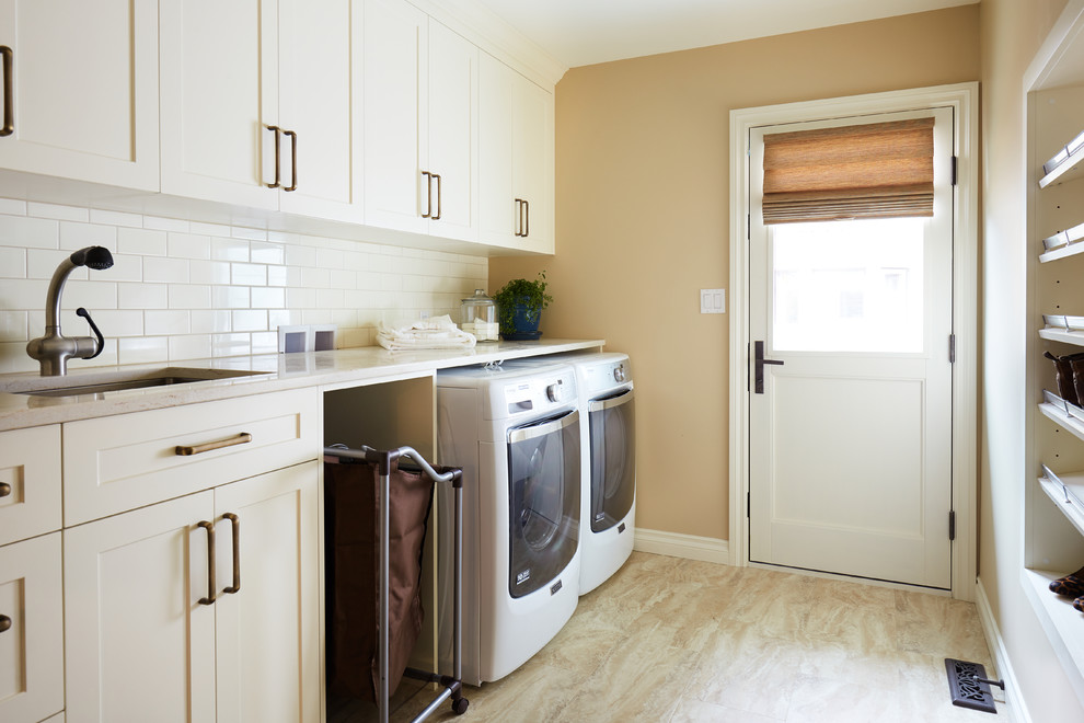 Design ideas for an expansive traditional single-wall utility room in Edmonton with a submerged sink, shaker cabinets, white cabinets, marble worktops, brown walls, a side by side washer and dryer, beige floors and beige worktops.