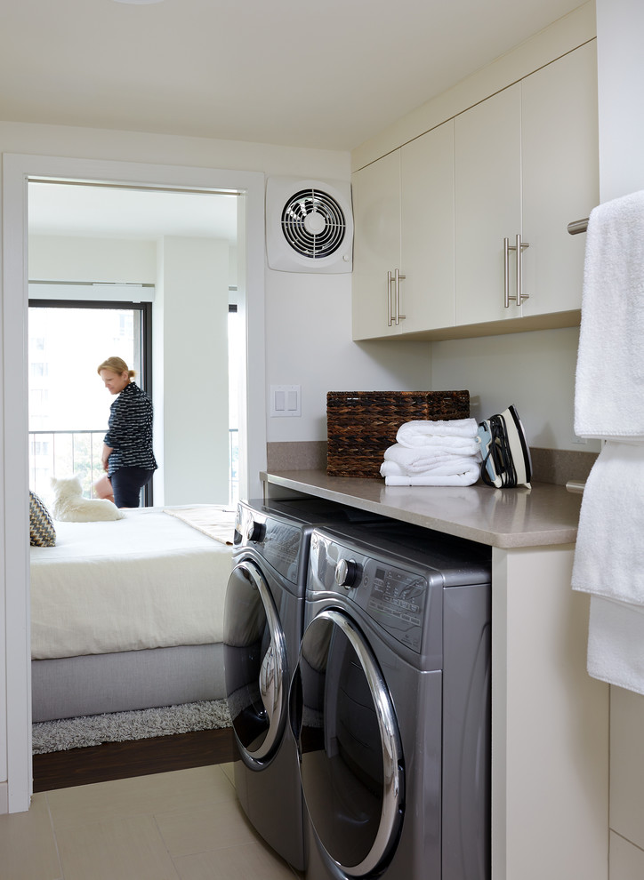 Example of a trendy beige floor laundry room design in DC Metro with flat-panel cabinets, beige cabinets, white walls, a side-by-side washer/dryer and beige countertops