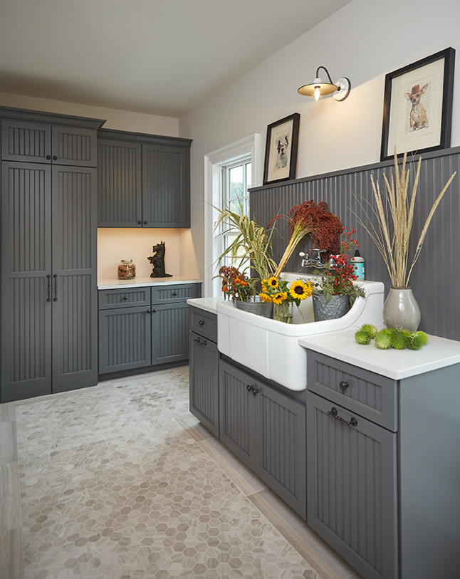 Inspiration for a mid-sized timeless l-shaped ceramic tile and beige floor dedicated laundry room remodel in Grand Rapids with a farmhouse sink, shaker cabinets, gray cabinets, quartz countertops and beige walls