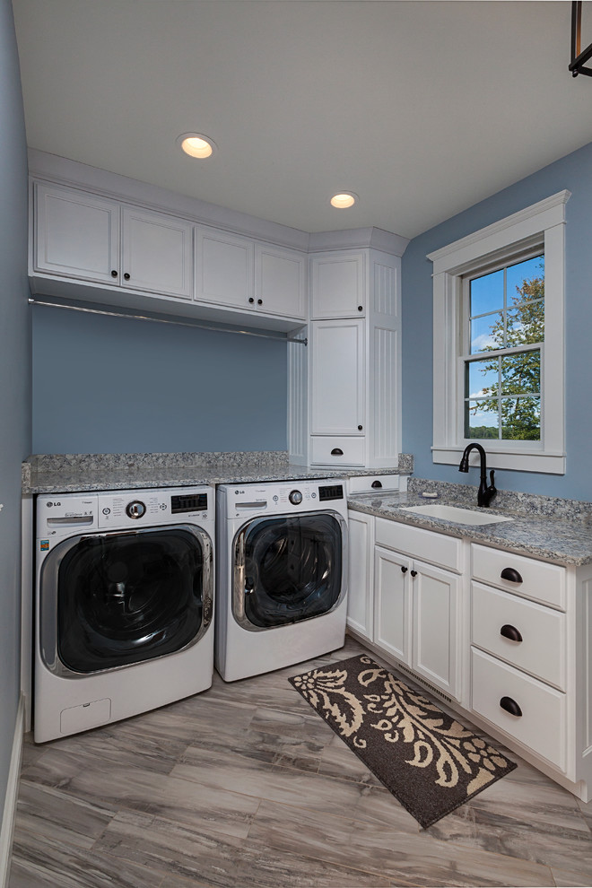 Exempel på ett mellanstort lantligt grå l-format grått grovkök, med en enkel diskho, luckor med infälld panel, vita skåp, granitbänkskiva, blå väggar, marmorgolv, en tvättmaskin och torktumlare bredvid varandra och flerfärgat golv